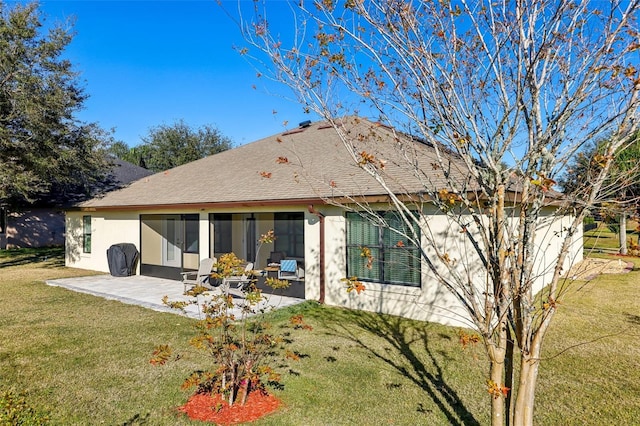 back of property with a yard and a patio area