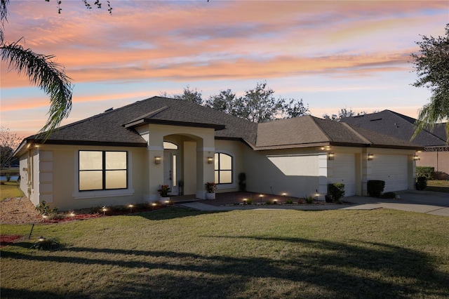 prairie-style home featuring a lawn and a garage