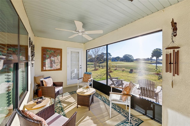 sunroom / solarium featuring ceiling fan and a rural view