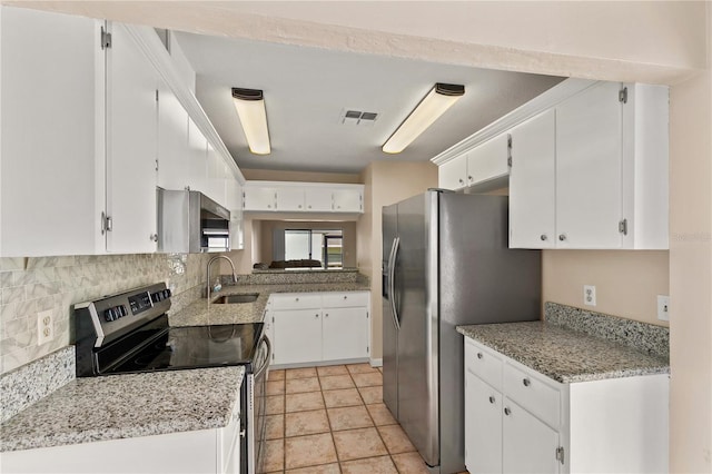 kitchen with light stone countertops, backsplash, stainless steel appliances, sink, and white cabinets