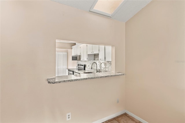 kitchen with sink, stainless steel appliances, backsplash, a textured ceiling, and white cabinets