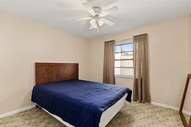 carpeted bedroom with ceiling fan and a textured ceiling