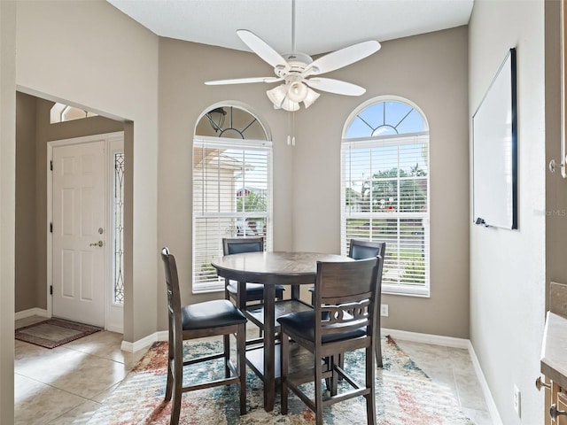 tiled dining room featuring vaulted ceiling, ceiling fan, and a healthy amount of sunlight