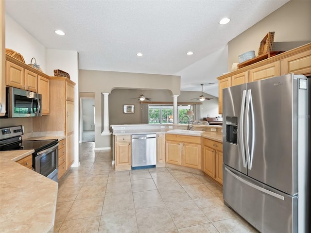 kitchen with sink, light brown cabinetry, appliances with stainless steel finishes, kitchen peninsula, and decorative columns