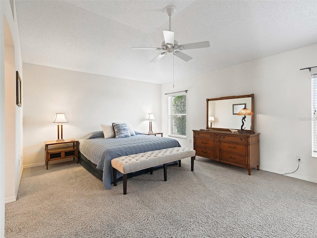 carpeted bedroom with ceiling fan and a textured ceiling