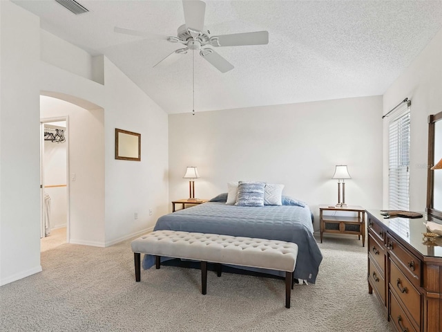 carpeted bedroom with a textured ceiling, ceiling fan, and vaulted ceiling