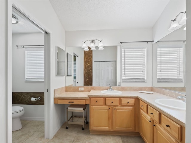 bathroom featuring tile patterned flooring, vanity, a textured ceiling, and toilet