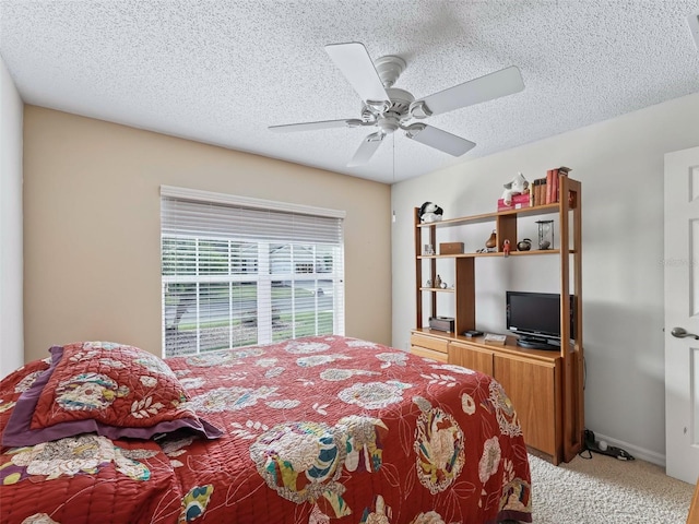 carpeted bedroom with ceiling fan and a textured ceiling