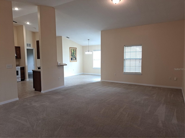 spare room with a chandelier, carpet floors, and lofted ceiling