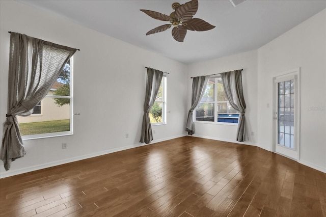 empty room featuring dark wood-type flooring and ceiling fan