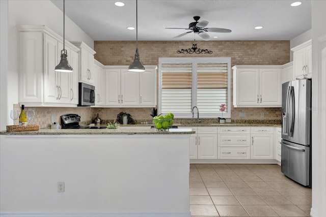 kitchen featuring decorative light fixtures, white cabinets, light tile patterned floors, light stone counters, and stainless steel appliances