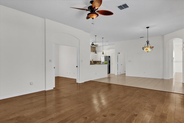 unfurnished living room featuring light hardwood / wood-style floors and ceiling fan