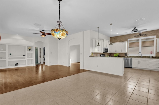 kitchen featuring white cabinetry, ceiling fan, appliances with stainless steel finishes, and decorative light fixtures