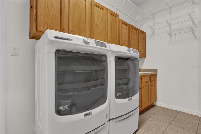 washroom featuring cabinets, independent washer and dryer, and light tile patterned floors