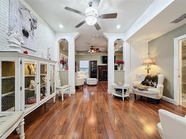 living area featuring ceiling fan and dark hardwood / wood-style flooring