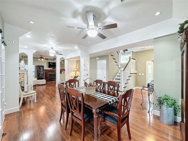 dining room with ceiling fan, wood-type flooring, and a textured ceiling