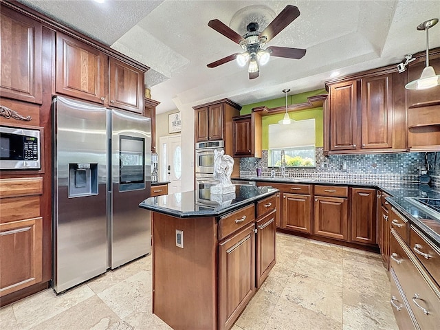 kitchen with appliances with stainless steel finishes, decorative light fixtures, sink, and tasteful backsplash