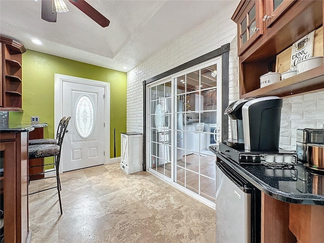 interior space with ceiling fan and a textured ceiling