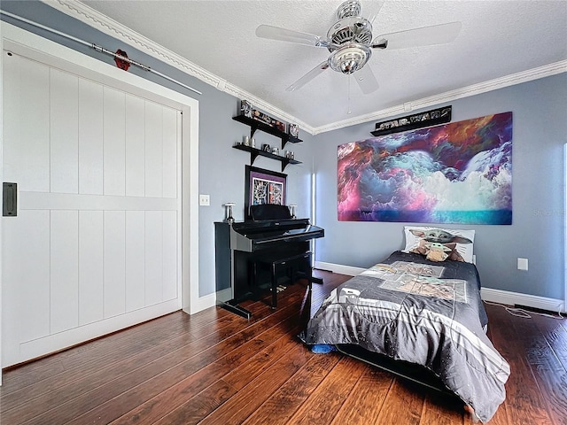 bedroom featuring ceiling fan, a textured ceiling, dark wood-type flooring, and ornamental molding