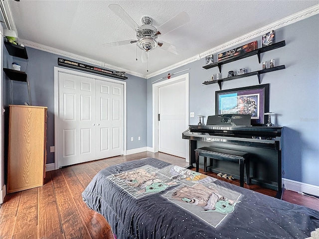 bedroom featuring a textured ceiling, a closet, dark wood-type flooring, and ornamental molding