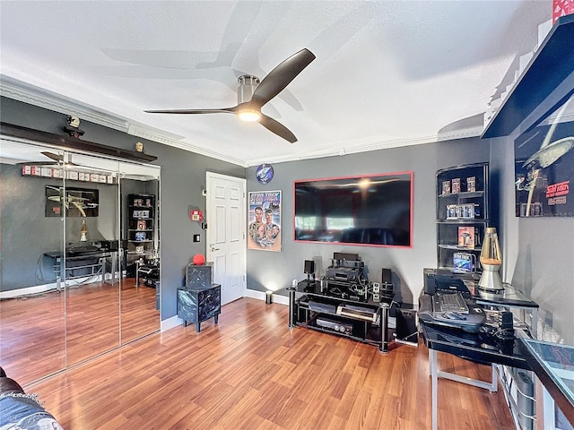 living room featuring hardwood / wood-style flooring, ceiling fan, ornamental molding, and a textured ceiling