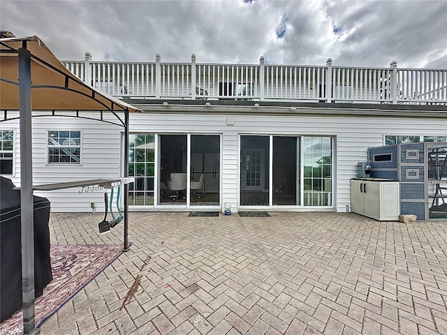 rear view of property featuring a patio area and a balcony