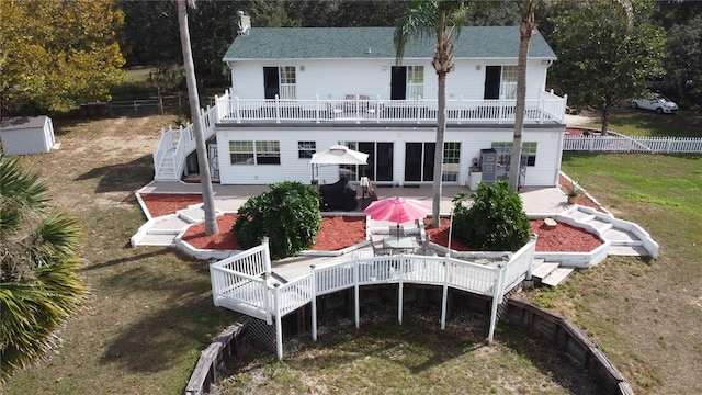 rear view of house featuring a patio area, a deck, and a lawn