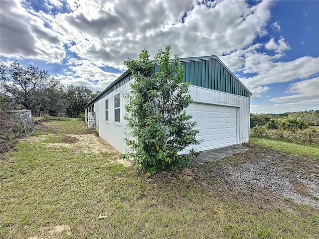 view of side of home with a garage, an outdoor structure, and a yard