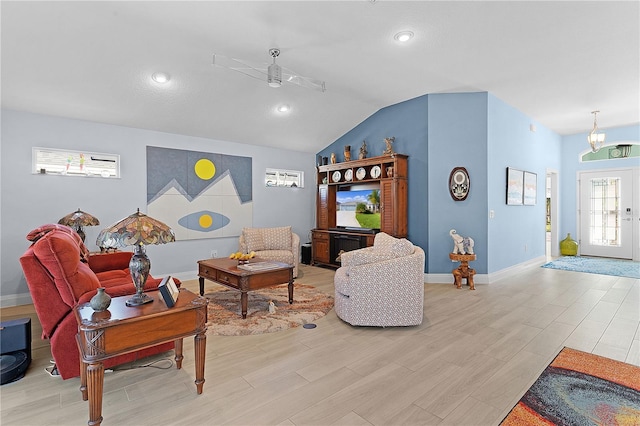 living room featuring ceiling fan, light wood-type flooring, and vaulted ceiling