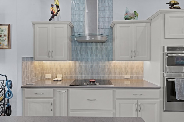 kitchen with white cabinetry, wall chimney exhaust hood, tasteful backsplash, double oven, and black electric cooktop