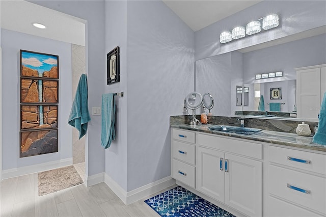 bathroom with vanity, a shower, and wood-type flooring