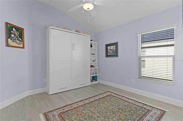 bedroom featuring ceiling fan, light wood-type flooring, and vaulted ceiling