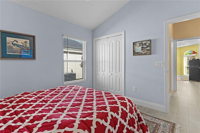 bedroom featuring a closet, hardwood / wood-style floors, and lofted ceiling