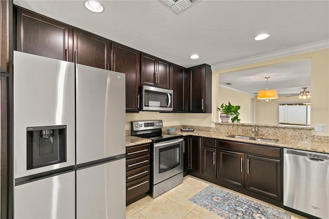 kitchen featuring sink, hanging light fixtures, stainless steel appliances, light tile patterned floors, and ornamental molding