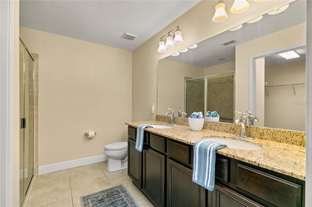 bathroom with walk in shower, tile patterned flooring, a textured ceiling, toilet, and vanity