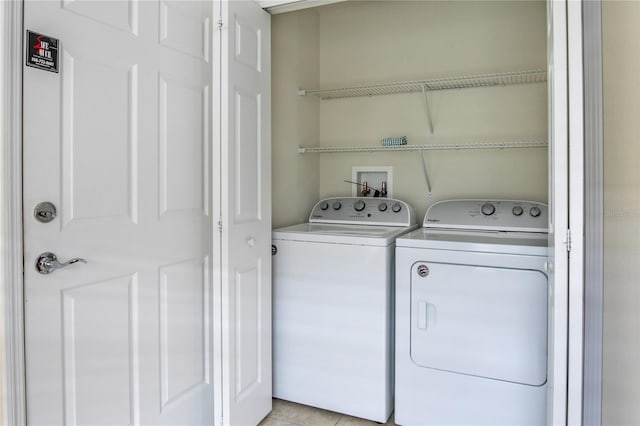 laundry room featuring light tile patterned floors and separate washer and dryer