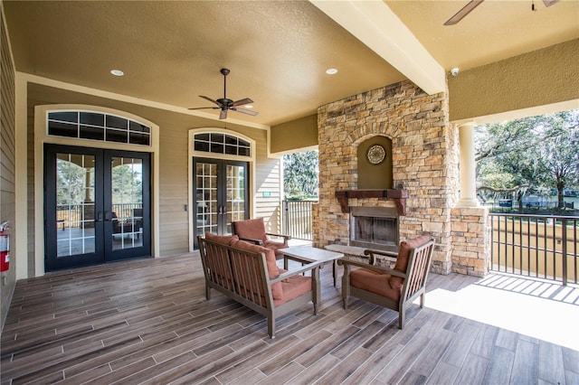 wooden terrace featuring an outdoor living space with a fireplace, ceiling fan, and french doors