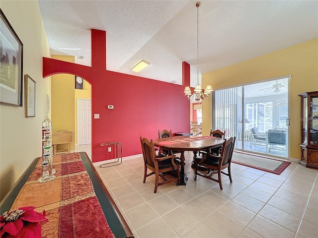 dining room with vaulted ceiling, tile patterned flooring, and a textured ceiling