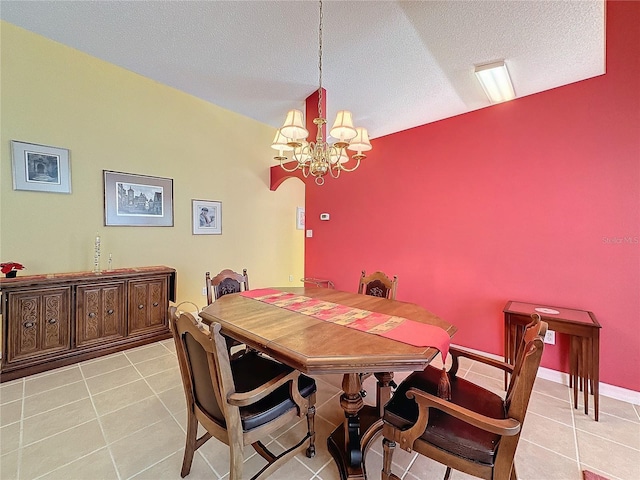 dining area with a textured ceiling, light tile patterned floors, a chandelier, and lofted ceiling