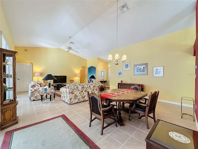 tiled dining room with ceiling fan with notable chandelier and vaulted ceiling