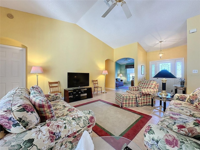 tiled living room featuring ceiling fan and vaulted ceiling