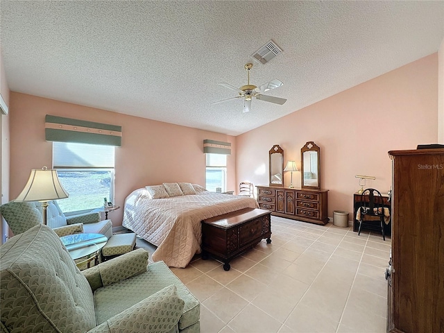 tiled bedroom featuring ceiling fan and a textured ceiling