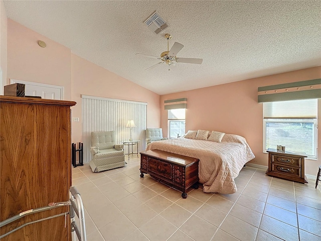 tiled bedroom with ceiling fan, lofted ceiling, and a textured ceiling