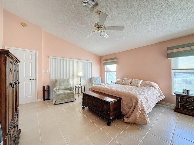 bedroom featuring ceiling fan, light tile patterned floors, a textured ceiling, and vaulted ceiling