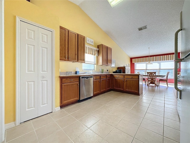 4634 Summerbridge Cir, Leesburg, FL 34748 - kitchen with vaulted ceiling, stainless steel dishwasher, a textured ceiling, light tile patterned floors, and brown cabinetry