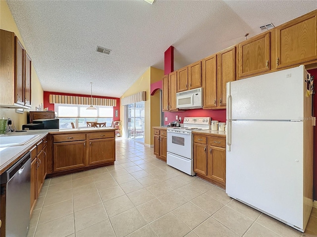 kitchen featuring a textured ceiling, vaulted ceiling, decorative light fixtures, white appliances, and light tile patterned floors