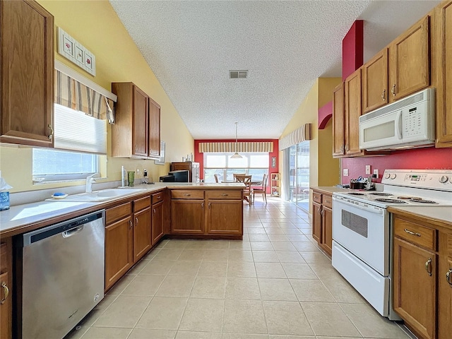 kitchen featuring white appliances, lofted ceiling, a textured ceiling, decorative light fixtures, and kitchen peninsula