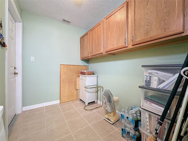 laundry room featuring light tile patterned floors and a textured ceiling