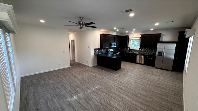 kitchen with ceiling fan, stainless steel appliances, tasteful backsplash, hardwood / wood-style flooring, and ornamental molding