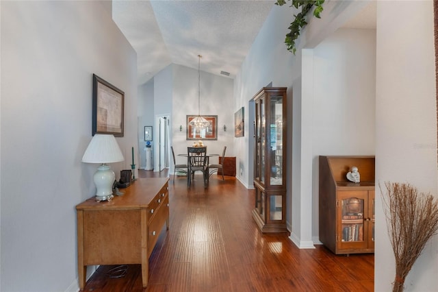 4130 Capland Ave, Clermont, FL 34711 - hall with dark wood finished floors, lofted ceiling, a chandelier, and baseboards